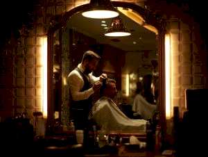 “Barber styling men’s haircut in Istanbul salon with modern warm lighting”